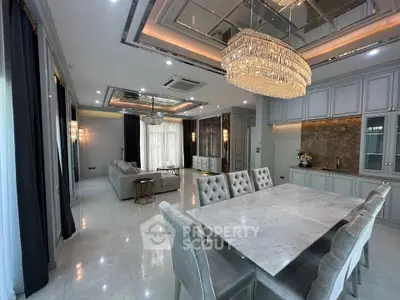 Luxurious open-plan living and dining area with elegant chandelier and modern decor