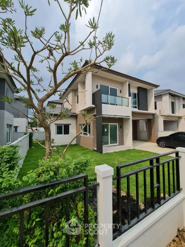 Modern two-story house with lush green lawn and sleek balcony design