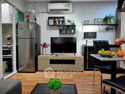 Modern living room with stylish decor, TV, and open kitchen layout in a cozy apartment.
