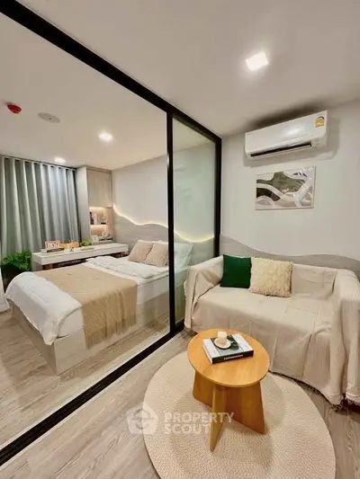 Modern studio apartment with glass partition, cozy living area, and stylish bedroom.