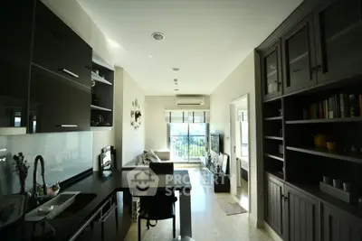 Modern open-plan living room with sleek kitchen and balcony view