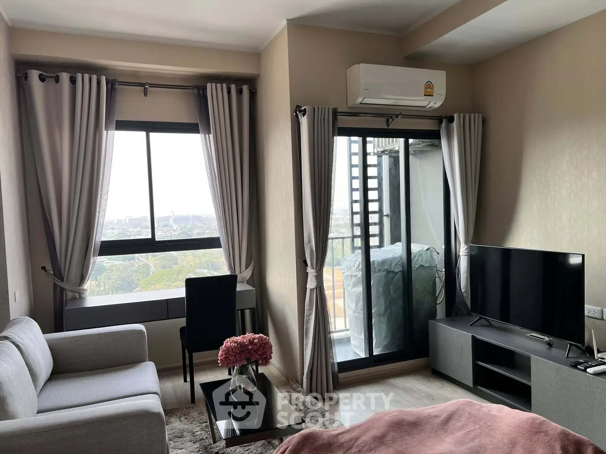 Modern living room with city view, featuring sleek furniture and large windows for natural light.