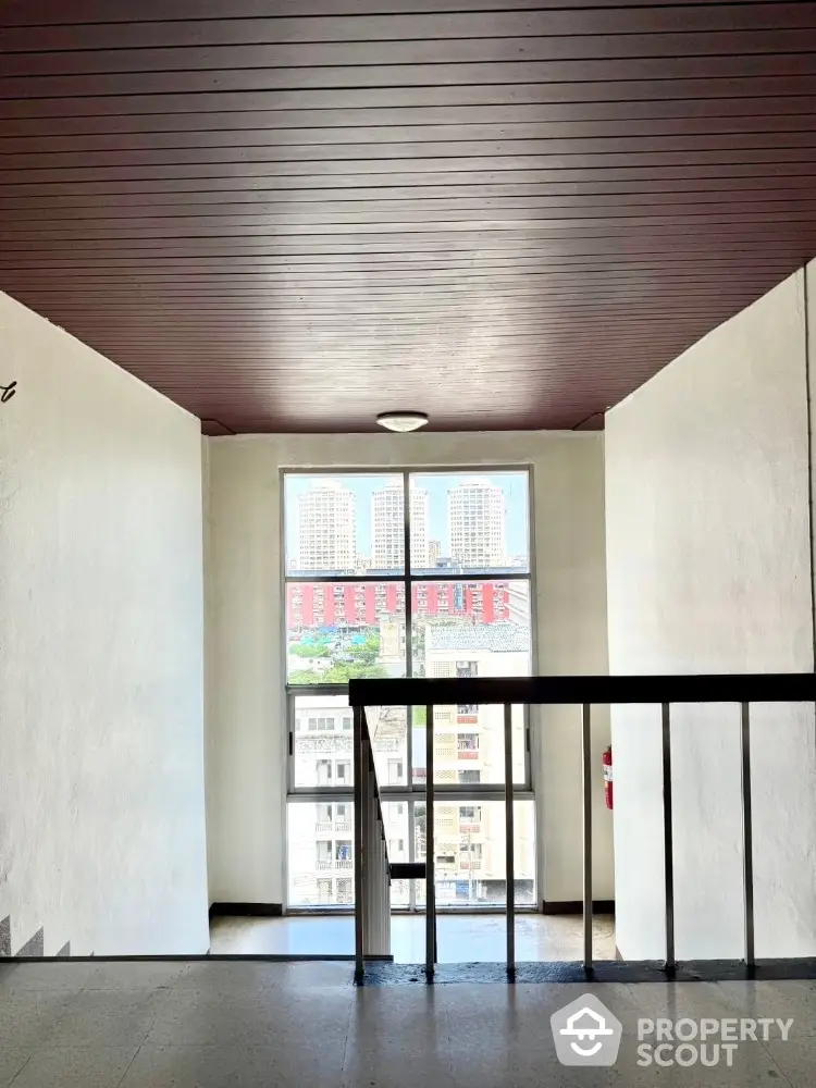 Bright building corridor with city view through large window