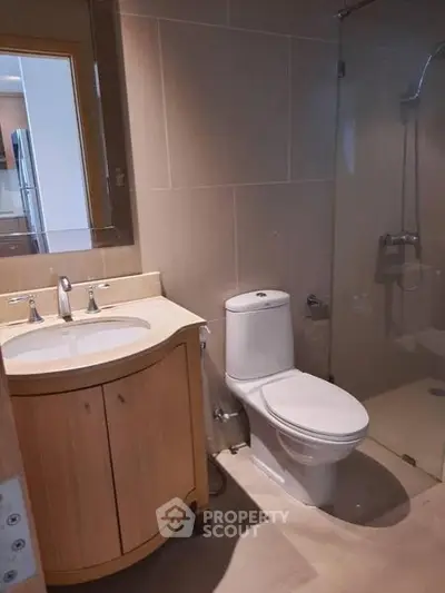 Modern bathroom with sleek fixtures and glass shower enclosure in a contemporary apartment.