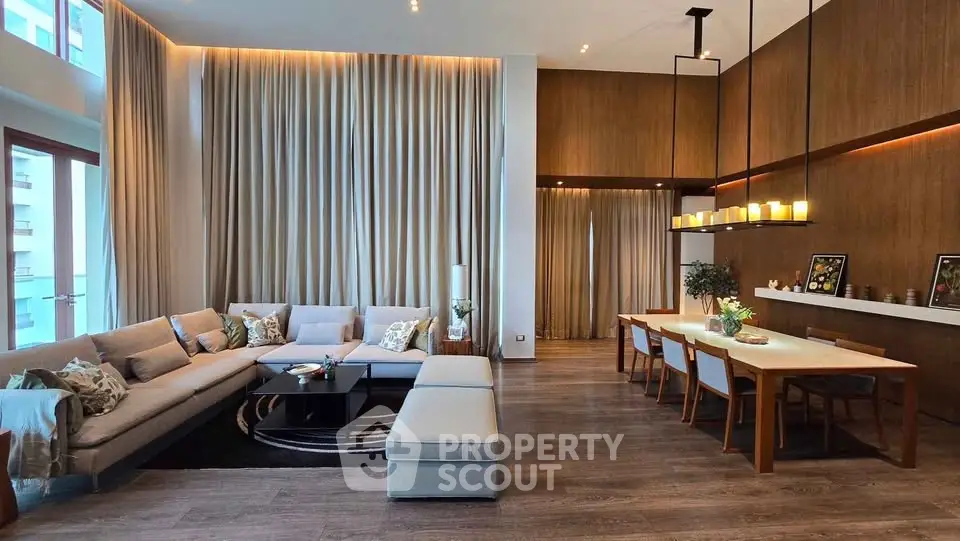 Luxurious modern living room with high ceilings, elegant lighting, and stylish furniture in a spacious open layout.