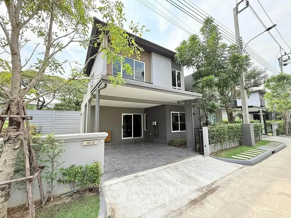 Modern two-story house with driveway and lush greenery in a serene neighborhood.