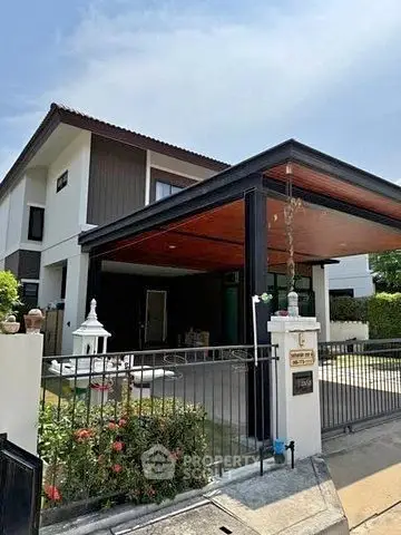 Modern two-story house with carport and landscaped garden in a serene neighborhood.