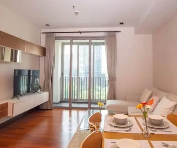 Modern living room with balcony view, stylish furniture, and elegant dining setup in a high-rise apartment.
