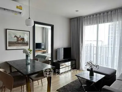 Modern living room with stylish decor and balcony view in a contemporary apartment.