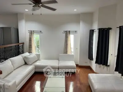 Spacious living room with elegant white sectional sofa and hardwood floors