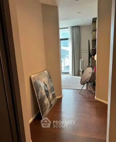 Modern apartment hallway leading to a stylish living area with large windows and contemporary decor.