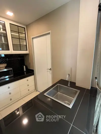 Modern kitchen with sleek black countertops and stainless steel sink