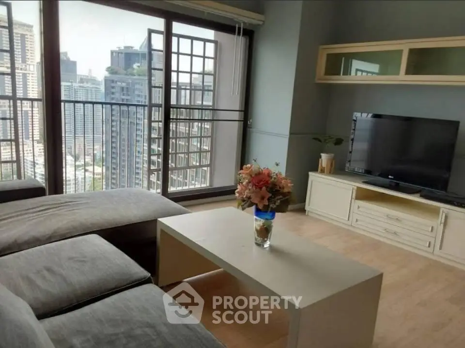 Spacious living room with city view, modern furniture, and large windows in urban apartment.