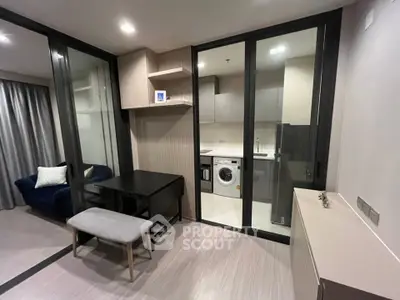 Modern apartment with open layout, featuring a cozy living area and a compact kitchen with built-in appliances.