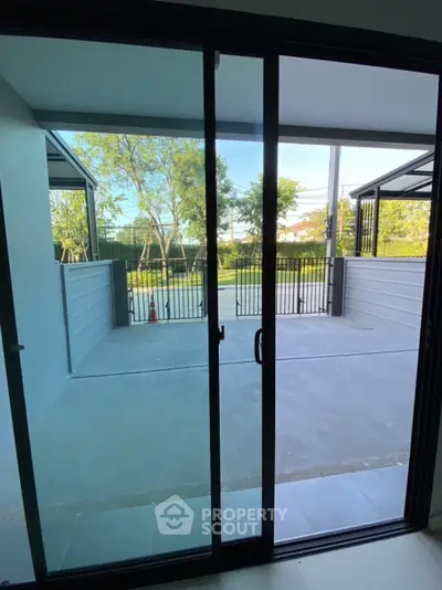 Spacious patio with sliding glass doors and garden view in modern home