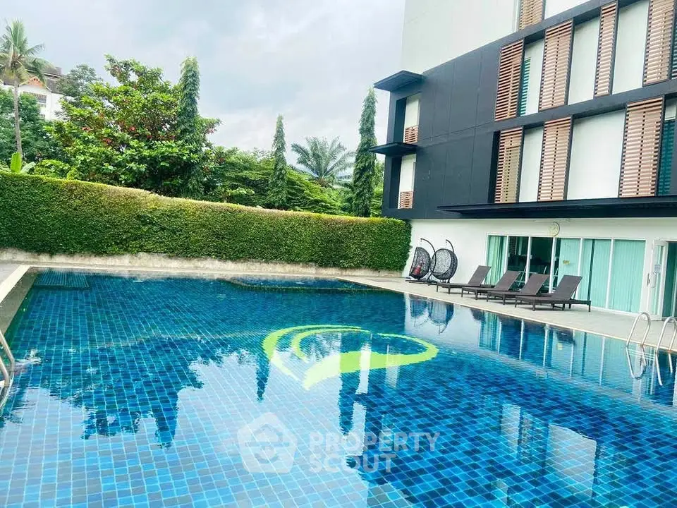 Luxurious residential building with a pristine blue swimming pool and lush greenery.