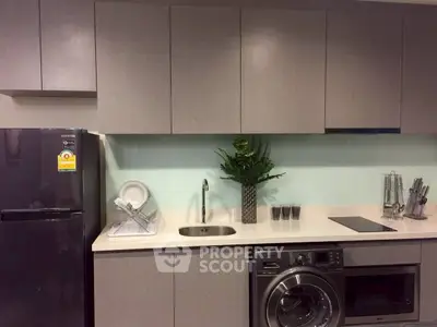 Modern kitchen with sleek cabinetry, washing machine, and built-in appliances for efficient living.