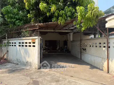 Charming residential property with spacious carport and lush greenery, perfect for family living.