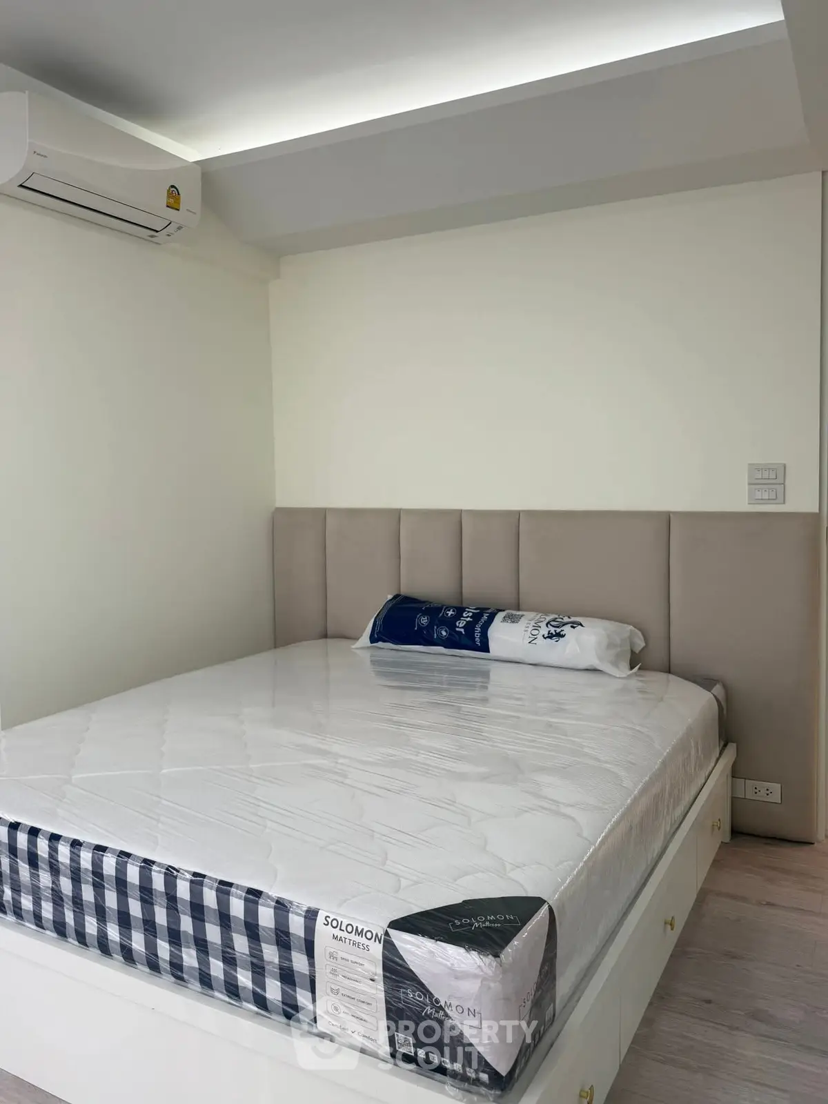 Modern bedroom with stylish bed and air conditioning unit, perfect for comfort and relaxation.