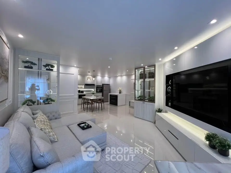 Luxurious modern living room with open kitchen, sleek design, and elegant furnishings.