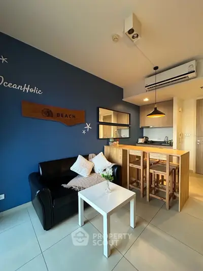 Chic living room with modern kitchen in open layout, featuring stylish decor and cozy seating.
