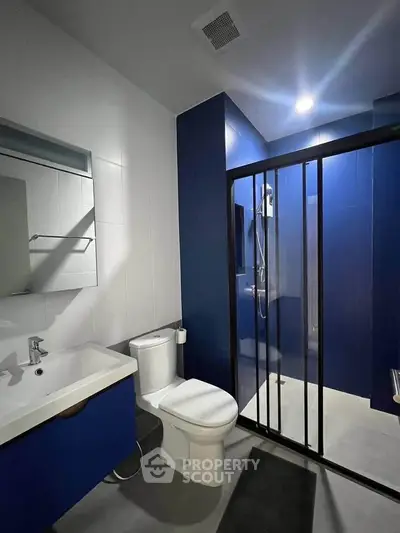 Modern bathroom with sleek blue accents and glass shower enclosure