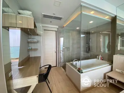 Luxurious modern bathroom with glass shower and built-in bathtub offering stunning ocean view.