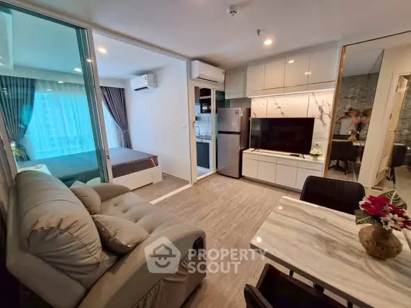 Modern open-plan living room with kitchen and bedroom in a stylish apartment.