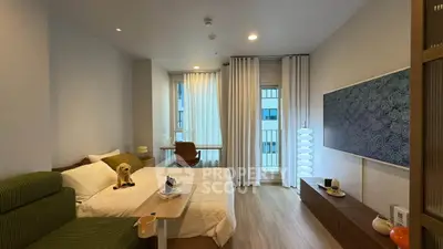Modern bedroom with stylish decor, featuring a cozy bed, elegant lighting, and a large window for natural light.