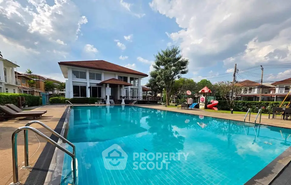 Luxurious residential pool area with modern clubhouse and lush landscaping.