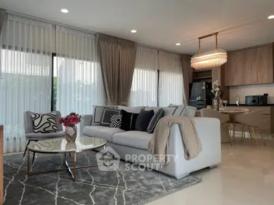 Luxurious modern living room with elegant decor and open kitchen layout, featuring plush seating and stylish lighting.