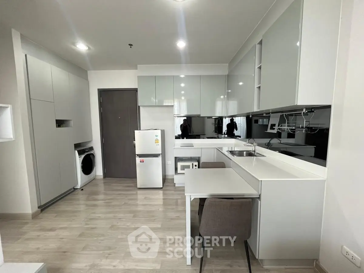 Modern kitchen with sleek cabinetry and integrated appliances in a stylish apartment.