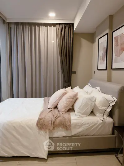 Elegant bedroom with cozy decor and soft lighting, featuring modern art and plush bedding.