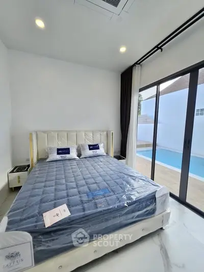 Luxurious bedroom with pool view and modern furnishings in a stylish home.