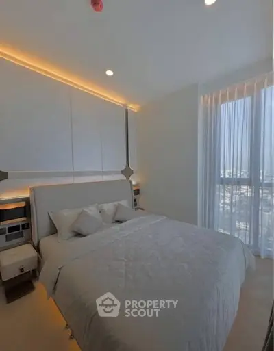 Luxurious bedroom with modern design and large windows offering natural light.
