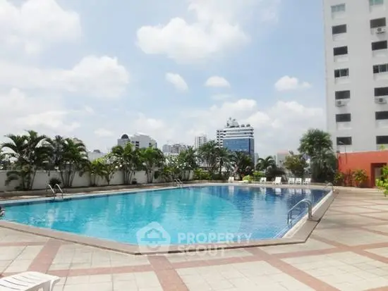 Luxurious rooftop pool with city skyline views in modern residential building.