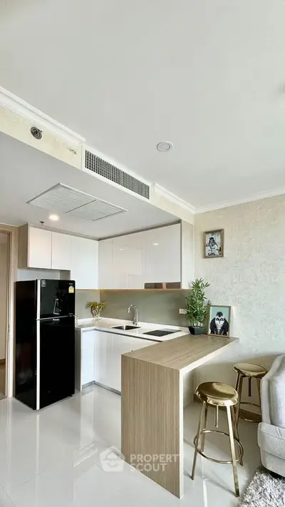 Modern kitchen with sleek white cabinets and breakfast bar in stylish apartment