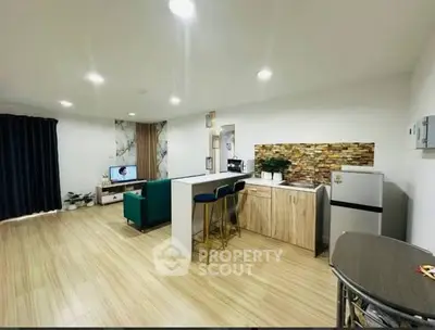 Modern open-plan living room with stylish kitchen and cozy seating area