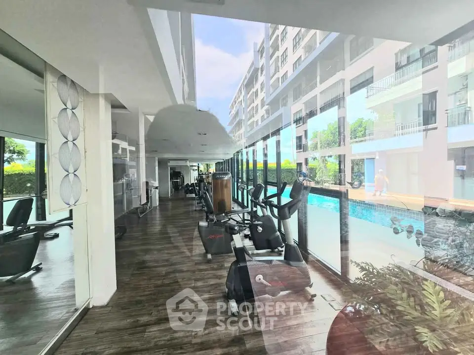 Modern gym with pool view in luxury residential building
