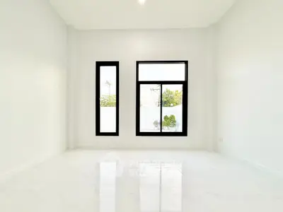 Spacious empty room with large windows and glossy white flooring
