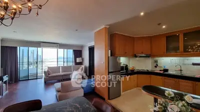 Spacious open-plan living room with modern kitchen and stunning city view balcony.