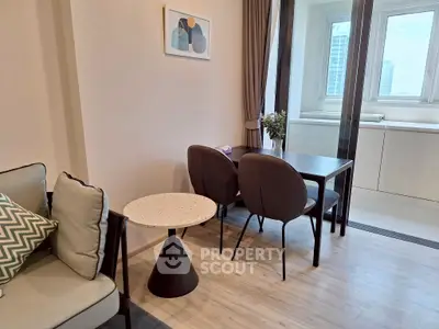 Modern living room with dining area and large window view in a stylish apartment.