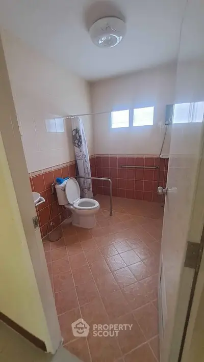 Spacious bathroom with accessible features and natural light.