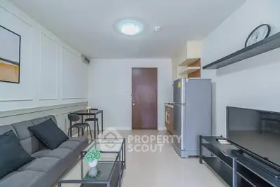 Modern living room with sleek furniture and open kitchen layout in a stylish apartment.