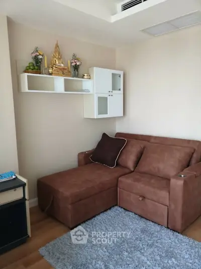 Cozy living room with brown sofa and decorative shelf in modern apartment