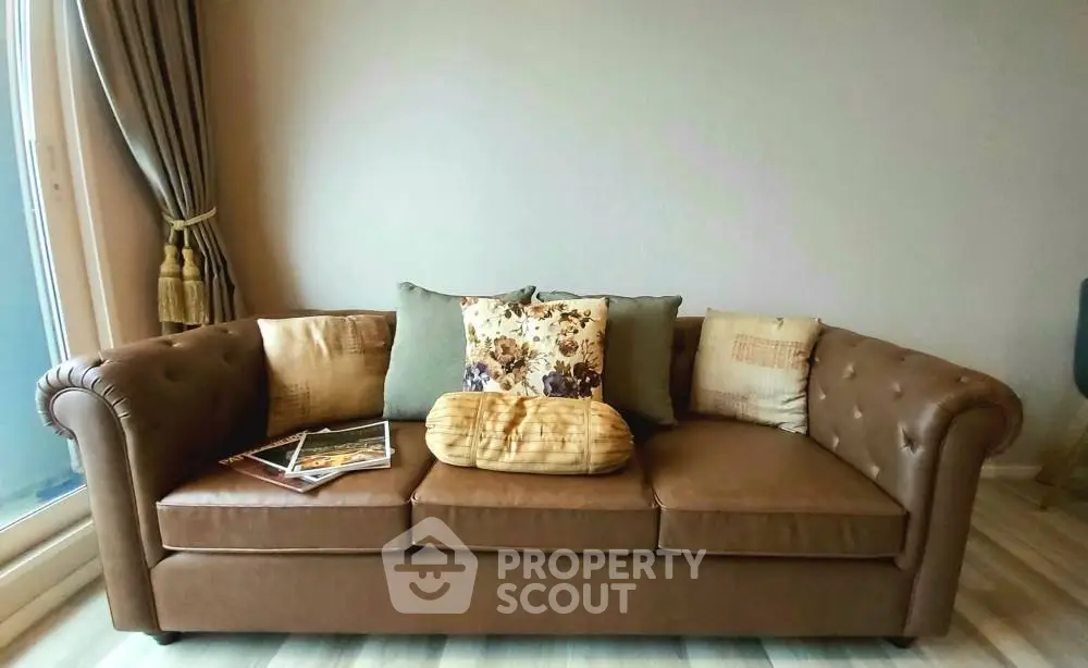 Elegant living room with a stylish brown leather sofa and decorative cushions.