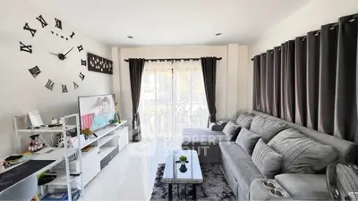 Modern living room with stylish decor, large gray sectional sofa, and wall-mounted TV, perfect for relaxation.
