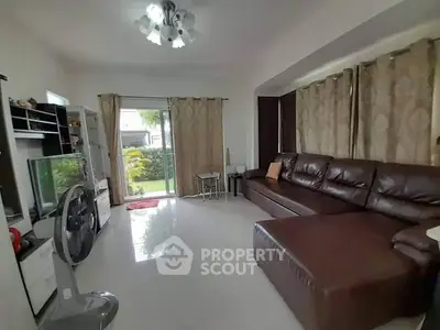 Spacious living room with leather sofa and garden view