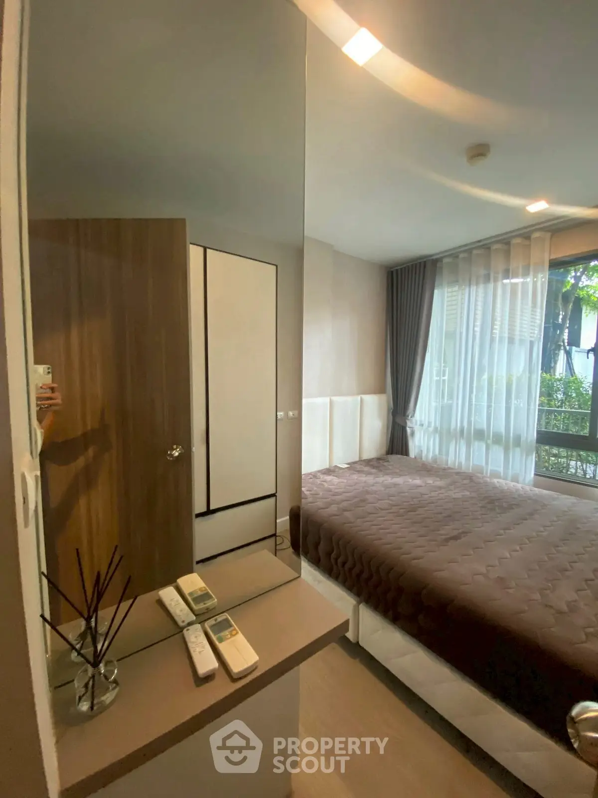 Cozy bedroom with large window and modern decor in a stylish apartment.