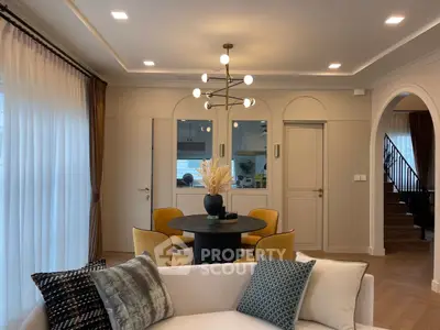 Elegant living room with modern chandelier and cozy seating area, perfect for stylish gatherings.